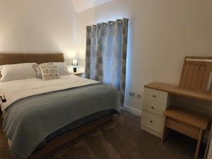 a bedroom with a bed and a dresser and a window at 2-Bed Barn Hot Tub & Pet Friendly near Muirkirk in Cumnock