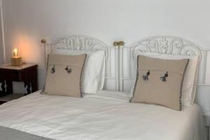 a white bed with two pillows on top of it at Central Ericeira 4 Bedrooms by Lovely Bay - Fte Cabo in Ericeira