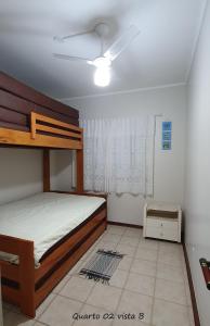 a bedroom with a bed and a ceiling fan at Apartamento Amplo Praia Grande Ubatuba JJ Mendes in Ubatuba