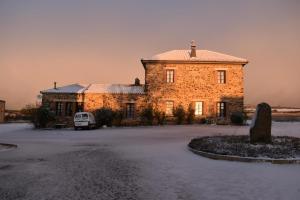 盧耶哥索摩查的住宿－Hotel Rural Molino del Arriero，一座大型砖砌建筑,前面有一辆汽车