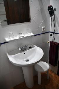 La salle de bains est pourvue d'un lavabo blanc et d'un miroir. dans l'établissement Hotel Rural Molino del Arriero, à Luyego de Somoza