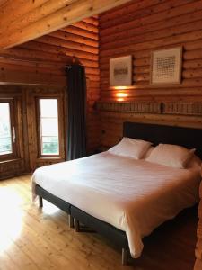 a bedroom with a large bed in a log cabin at maison piscine chaufée in Porto-Vecchio