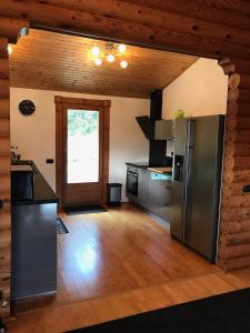 cocina con electrodomésticos de acero inoxidable y techo de madera en maison piscine chaufée, en Porto Vecchio