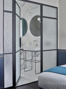 a bathroom with a mirror and a bed at Amosa Liège City Centre Hotel in Liège