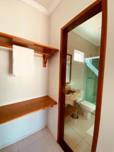 a bathroom with a toilet and a sink and a mirror at Bella Spiaggia Suítes Centro de Flecheiras, perto da praia in Flecheiras