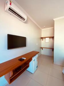a living room with a flat screen tv on the wall at Bella Spiaggia Suítes in Flecheiras
