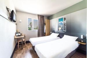 a hotel room with two beds and a desk at B&B HOTEL Perpignan Saleilles in Perpignan +31 photos
