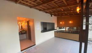 a kitchen with white tile flooring and wooden cabinets at Hotel Santana - Posto da Mata BA in Pasto da Mata