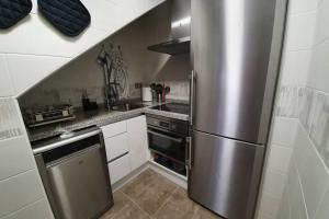 uma cozinha com um frigorífico de aço inoxidável em Dúplex a pie del telecabina de La Massana - Pal Vallnord - 642 em La Massana