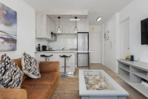 un soggiorno con divano e una cucina di Modern 1 Bedroom in Blouberg a Città del Capo