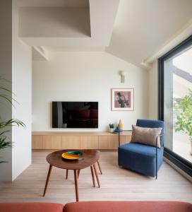 uma sala de estar com uma cadeira azul e uma mesa em Apartahotel Líbere Vitoria em Vitoria-Gasteiz