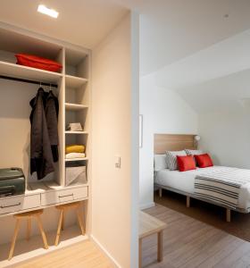 um quarto com uma cama e um closet em Apartahotel Líbere Vitoria em Vitoria-Gasteiz