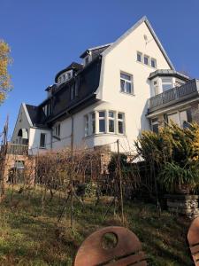 une maison blanche avec un toit noir dans l'établissement Ferienwohnung Burkhardt, à Meissen