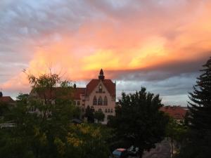 une église avec un coucher de soleil en arrière-plan dans l'établissement Ferienwohnung Burkhardt, à Meissen