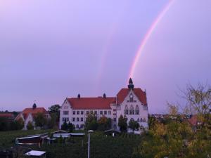 un arco iris sobre un edificio blanco con una casa en Ferienwohnung Burkhardt, en Meißen
