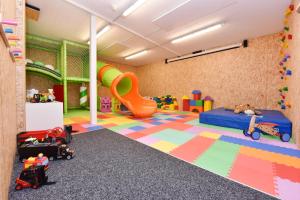 una sala de juegos para niños con juguetes y un tobogán en Salzgeber Appartements, en Sankt Gallenkirch