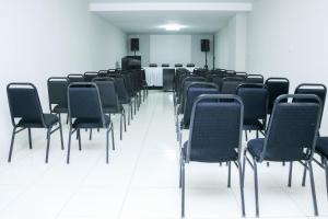 une pièce vide avec des chaises noires et un sol blanc dans l'établissement Avelan Plaza Hotel, à Nossa Senhora da Glória