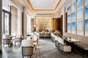 a restaurant with white chairs and tables and windows at Four Seasons Hotel One Dalton Street, Boston in Boston