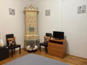 a room with a bed and two chairs and a clock at Irina Apartments in Piteşti