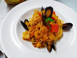 a plate of food with pasta and vegetables on it at The Wave in Sidari