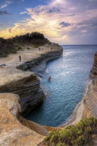 a group of people swimming in a body of water at The Wave in Sidari