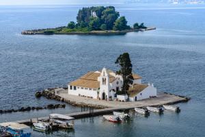 an island with a church and boats in the water at The Wave in Sidari
