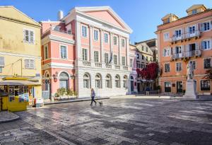 a person walking a dog in the middle of a street at The Wave in Sidari