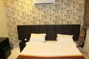 a bedroom with a large bed with a black headboard at Oroub El Forssan in Buraydah
