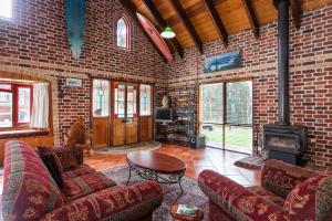 a living room with a brick wall and a fireplace at Chianti Cottages in Torquay