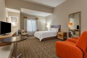 ein Hotelzimmer mit einem Bett und einem Flachbild-TV in der Unterkunft Candlewood Suites Fargo South-Medical Center, an IHG Hotel in Fargo