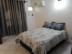 1 dormitorio con 1 cama con manta y almohadas en Departamento Boulevard MZO, en Manzanillo