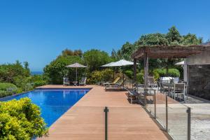 Una piscina con sillas y sombrillas al lado en Luxury Beachfront Villa, en Colares