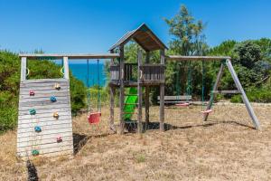 un parque infantil con 2 columpios y una estructura de juegos en Luxury Beachfront Villa, en Colares