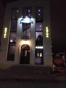 a building with a sign on it at night at Hotel Milana in Orenburg