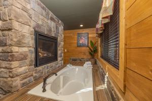 a bath tub in a room with a stone wall at BearVue Point chalet in Gatlinburg