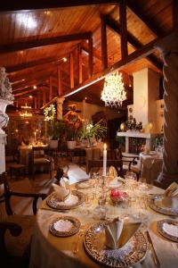 a dining room with a table with plates and glasses at La Mirage Garden Hotel & Spa in Cotacachi