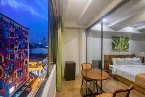 a bedroom with a bed and a table and a window at Balmoral Hotel San José CR, Historic District in San José +39 photos