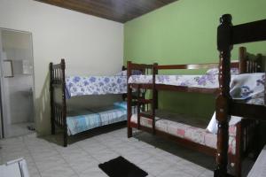 a room with three bunk beds in a room at Pousada Jambo Trindade in Trindade