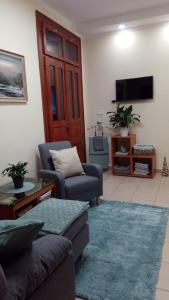 a living room with a couch and a tv at Diána Apartmanház in Keszthely