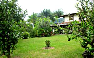 un patio verde con una casa al fondo en Finca La Esperanza, en Calima