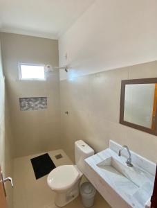 a bathroom with a white toilet and a sink at 4ª Cia Hostel e Pousada in Fortaleza