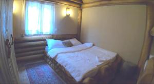 a small bed in a room with a window at Apartman Romanija Dolina mira in Pale