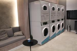 een woonkamer met 4 wasmachines en een bank bij 360 Moema in Sao Paulo