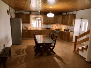 a kitchen with a table and chairs and a refrigerator at Quinta do Torgal - Alojamento Local in Unhais da Serra