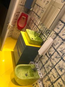 baño con lavabo verde y aseo rojo en Ziggla Luxury Properties, en Londres