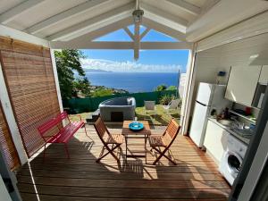 un patio con tavolo e sedie su un ponte di Bungalow Palbéa supérieur avec SPA et vue mer a Schœlcher