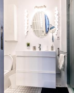 a white bathroom with a sink and a mirror at Casa Vista Marina in Ponta Delgada