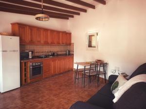 a kitchen with a couch and a table and a refrigerator at Casas Blancas - Suite 1 in Tasartico