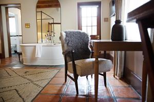 a bathroom with a chair and a bath tub at Beckhuis in Worcester