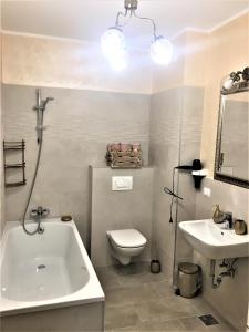 ein Badezimmer mit einer Badewanne, einem WC und einem Waschbecken in der Unterkunft 23 Residence in Braşov